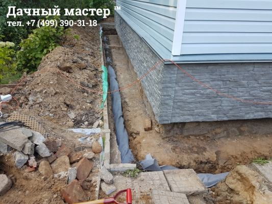 Дренажная труба в фильтре, уложенная в траншею